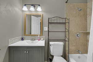 Full bathroom with toilet, vanity, and shower / tub combo