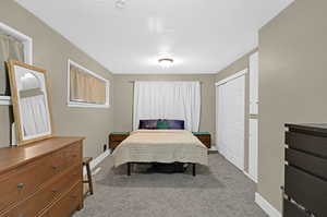 Carpeted bedroom featuring a closet and a textured ceiling