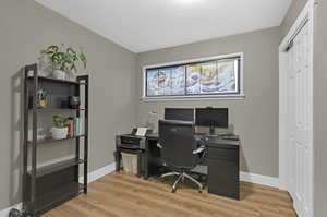 Office with wood-type flooring and a textured ceiling