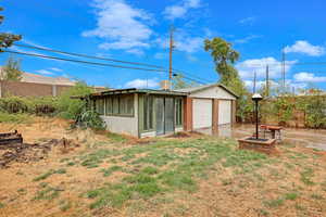 Rear view of house with cooling unit and a fire pit