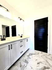 jack and Jill Bathroom featuring double vanity and entrance from bedroom and living area. Has seperate toilet and shower with privacy door