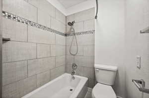 Bathroom with toilet and tiled shower / bath