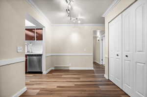 Unfurnished dining area with crown molding, hardwood / wood-style floors, and track lighting