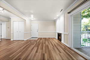 Unfurnished living room with crown molding and hardwood / wood-style flooring