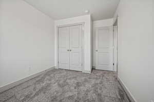 Unfurnished bedroom featuring carpet and a closet