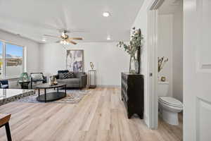 Living area featuring light wood-style flooring, ceiling fan, and recessed lighting