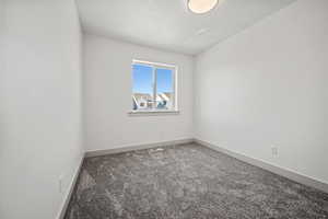 Spare room featuring carpet and baseboards