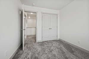 Unfurnished bedroom featuring carpet floors and a closet