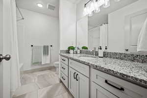 Full bath featuring vanity and shower / bath combination with curtain