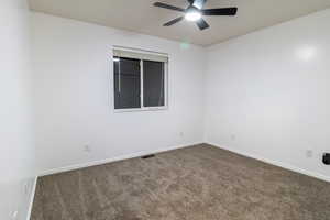 Carpeted empty room with ceiling fan