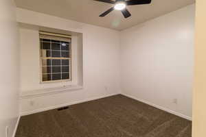 Carpeted empty room with ceiling fan