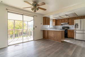 Kitchen featuring a wealth of natural light, stainless steel fridge (included), and dining area overlooking the covered back deck.