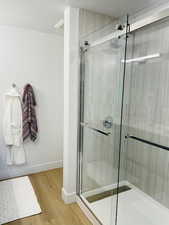 Bathroom featuring hardwood / wood-style floors and walk in shower