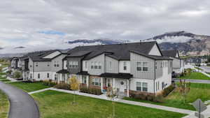 Townhome / multi-family property featuring a mountain view and a front yard