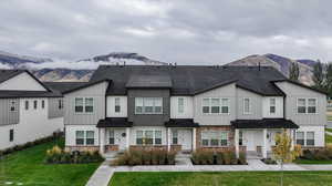 Townhome / multi-family property featuring a mountain view and a front lawn