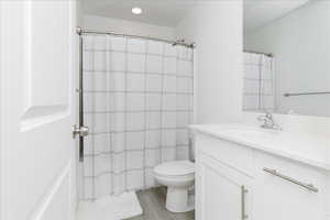 Bathroom featuring vanity, toilet, a shower with shower curtain, and hardwood / wood-style floors