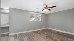 Spare room with dark wood-type flooring and ceiling fan