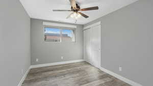 Unfurnished bedroom with a closet, light wood-type flooring, and ceiling fan