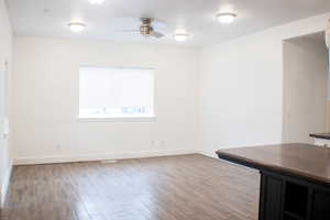 Spare room featuring dark wood-type flooring and ceiling fan