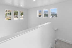 *Photo is of a previously built home of the same layout* Corridor featuring a mountain view and a healthy amount of sunlight