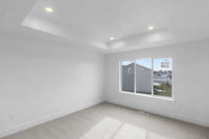 Primary bedroom featuring a tray ceiling