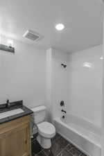 Full bathroom with vanity, toilet, a textured ceiling, and bathing tub / shower combination