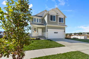 *Photo is of a previously built home of the same layout* View of front of house featuring a front lawn and a garage