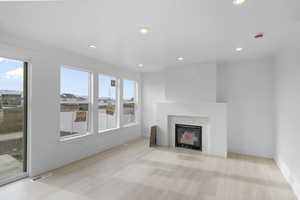 Unfurnished living room with light wood-type flooring and gas fireplace