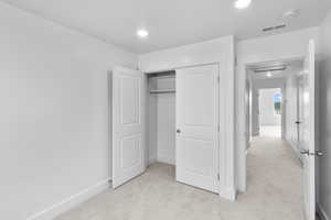 *Photo is of a previously built home of the same layout* bedroom featuring light colored carpet and a closet