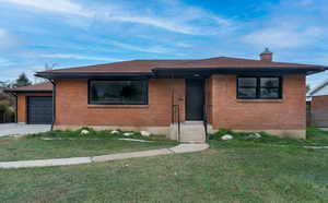 View of front of house featuring a front lawn and a garage