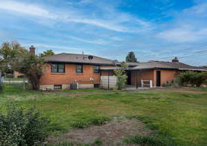 Rear view of property featuring a yard, a patio, and central AC unit