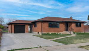 View of front of house featuring a front lawn and a garage