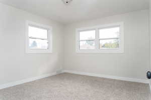 Empty room featuring carpet and plenty of natural light