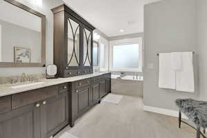 Bathroom featuring vanity, a bathtub, and tile patterned flooring