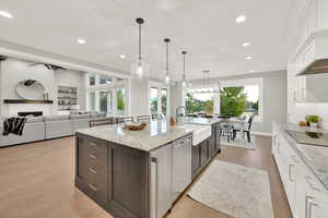 Kitchen featuring a healthy amount of sunlight, sink, and white cabinets