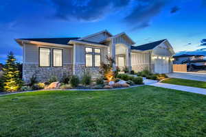 View of front facade featuring a garage and a lawn