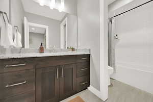 Full bathroom with vanity, toilet, tile patterned floors, and shower / bathtub combination with curtain