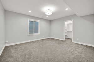 Carpeted empty room featuring a textured ceiling