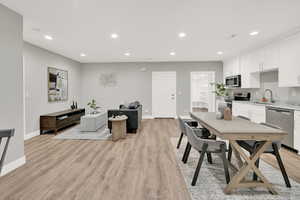 Dining room with sink and light wood-type flooring