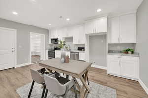 Kitchen featuring appliances with stainless steel finishes, sink, light wood-type flooring, and white cabinets