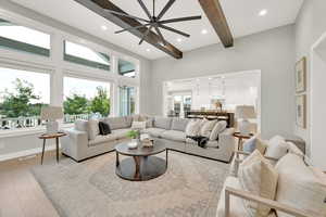 Living room with a towering ceiling, a healthy amount of sunlight, and hardwood / wood-style flooring