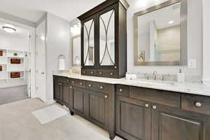 Bathroom with a shower with door, vanity, and tile patterned floors