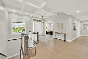 Hall featuring beam ceiling, coffered ceiling, and light hardwood / wood-style floors