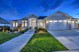 Craftsman inspired home with a garage and a lawn