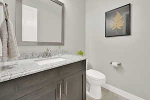 Bathroom featuring vanity, hardwood / wood-style flooring, and toilet