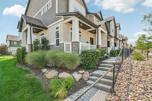 View of side of home with a porch and a yard