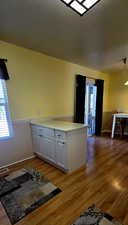 Kitchen featuring white cabinets, hardwood / wood-style floors, and kitchen peninsula