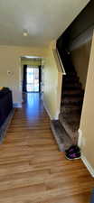 Hallway with a textured ceiling and light wood-type flooring