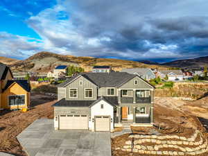 View of front of home with a mountain view, a garage, and a balcony