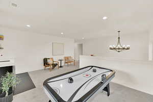 Loft Recreation room with carpet flooring and a chandelier